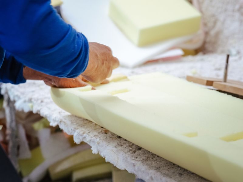 Una persona cortando espuma para tapizar.