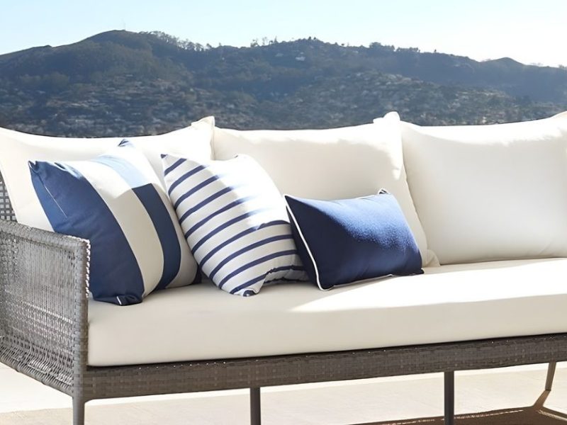 sofá blanco de exterior con cojines azules
