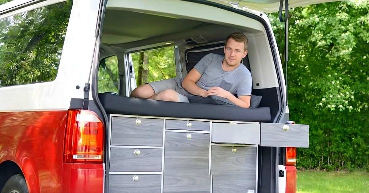 Un garçon se repose confortablement sur son matelas dans une camionnette à toit surélevé